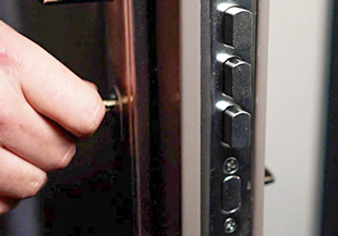 Male hand operates a key on a steel door